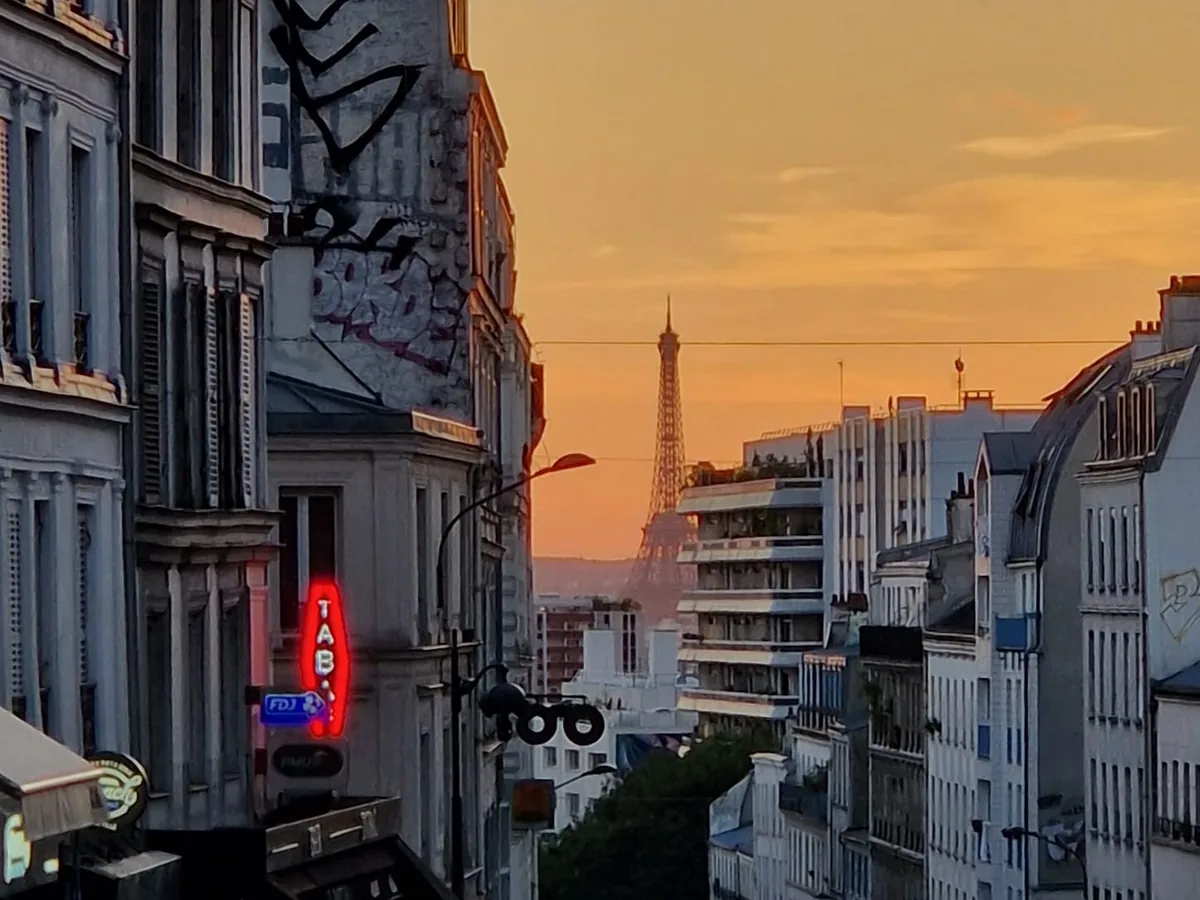 La tour Eiffel au coucher du soleil, vue depuis une rue de Paris